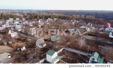 Aerial Drone View Flight Over small brick houses with a plot of land in the middle of the forest on an autumn day. Top view Aerial Drone View Flight Over small brick houses with a plot of land in the middle of the forest on an autumn day. Top view 89489449