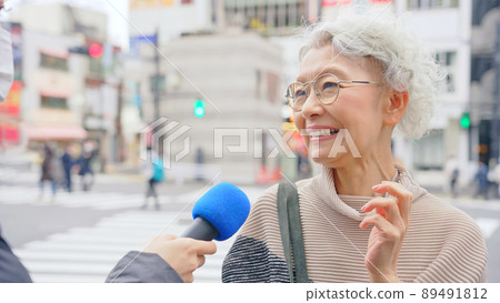 Senior woman undergoing a street interview Senior woman undergoing a street interview 89491812