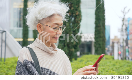 Senior woman using a smartphone in the city Senior woman using a smartphone in the city 89491820