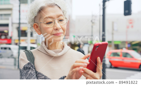 在城裡使用智能手機的高級女性 89491822