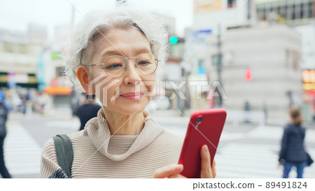Senior woman using a smartphone in the city Senior woman using a smartphone in the city 89491824