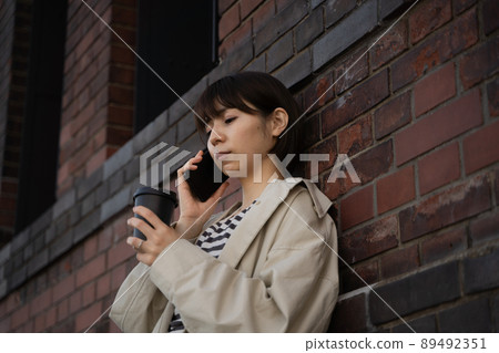 A woman talking on a smartphone 89492351