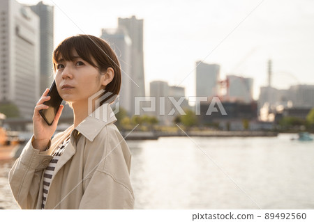 A woman turning around with her smartphone 89492560