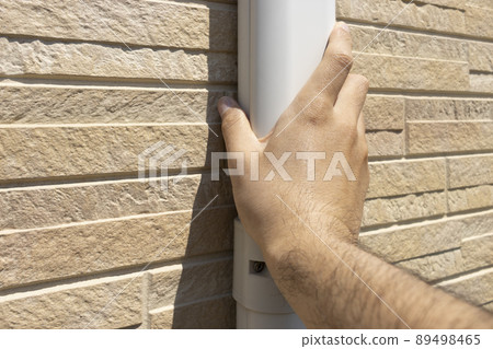 Male hand checking the hose cover of the air conditioner Male hand checking the hose cover of the air conditioner 89498465
