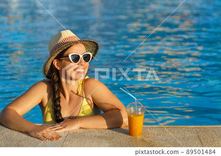 smiling woman drinking smoothies in swimming pool smiling woman drinking smoothies in swimming pool 89501484