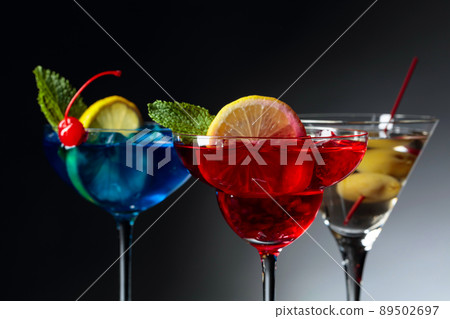 Two colorful cocktails and dry martini with green olives. 89502697