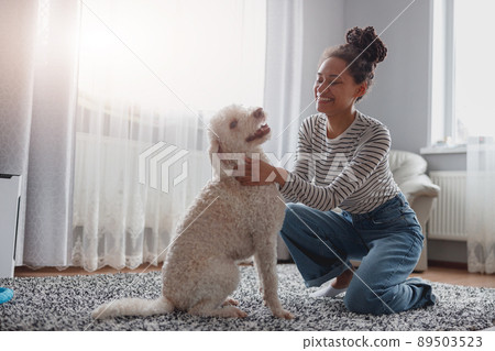 Little dog, poodle white puppy at home with young pretty woman owner. Pet love 89503523