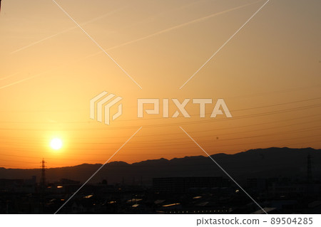 Contrails heading to the sunset 89504285
