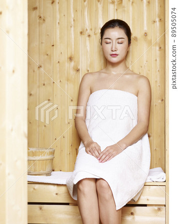 A Beautiful Woman Wearing A White Towel Takes A Sauna The Sauna Is