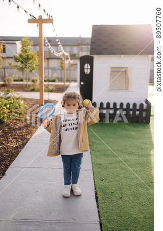 Cute little girl playing badminton in little kids city. Toy city for children Cute little girl playing badminton in little kids city. Toy city for children 89507760