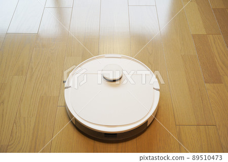 Image photo of a white cleaning robot cleaning the living room 89510473