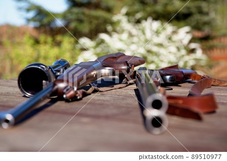 The weapons of choice for an expert hunter. Shot of two guns lying on a table outside. 89510977