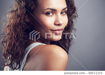 Gorgeous in all the right ways. Studio shot of a gorgeous young woman posing against a gray background. 89511255