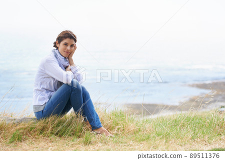 Isnt the view breathtaking. Portrait of a mature woman taking a break from her walk to take in the scenery. 89511376
