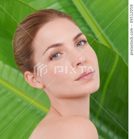 Beauty in nature. Cropped portrait of a beautiful young woman against the backdrop of palm leaves. 89512059
