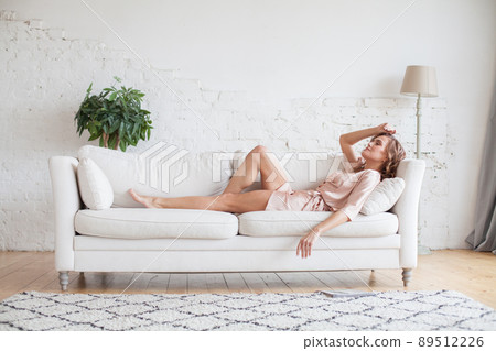 Beautiful woman resting on sofa at home 89512226