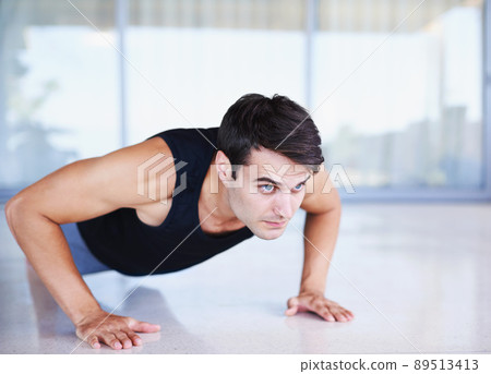 Just one more to go.... A cropped shot of a focused young man doing strength exercises at home. 89513413