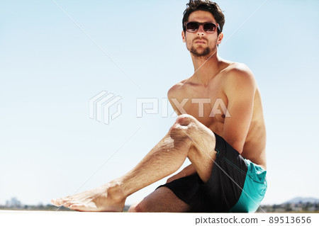 Laidback summers. A handsome young male wearing sunglasses while relaxing on a sunny summer day - Copyspace. 89513656