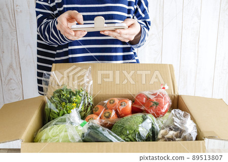 一個女人打開一個裝滿蔬菜的盒子 一個女人打開一個裝滿蔬菜的盒子 89513807