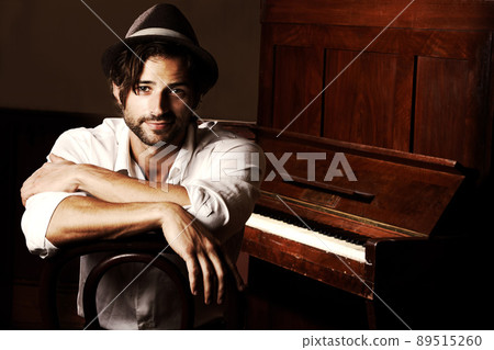 He makes music for the soul. Portrait of a young musician sitting in front of his piano. 89515260