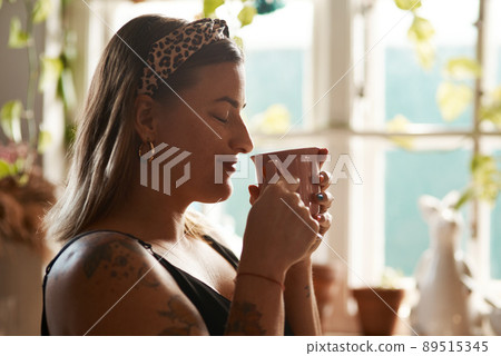 So this is what heaven smells like. Shot of a young woman having a relaxing coffee break at home. 89515345