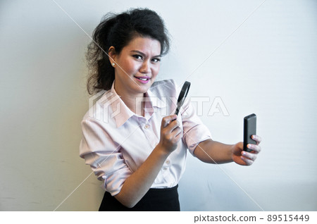Business woman examine mobile phone by magnifier Business woman examine mobile phone by magnifier 89515449