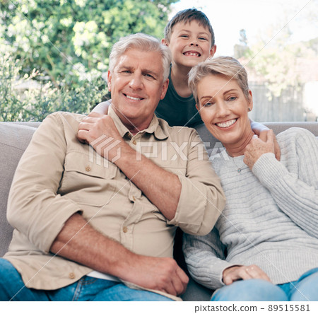 Happiness is all in the genes. Portrait of an adorable little boy relaxing with his grandmother and grandfather on the sofa at home. 89515581