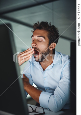 My brain is starting to fall asleep. Shot of a young businessman yawning while working late in an office. My brain is starting to fall asleep. Shot of a young businessman yawning while working late in an office. 89515663