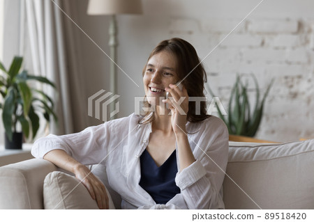 Happy pretty freckled girl talking on cellphone at home Happy pretty freckled girl talking on cellphone at home 89518420