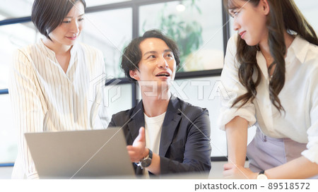 Three business people having a meeting in front of a PC 89518572