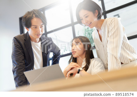 Three business people having a meeting in front of a PC 89518574