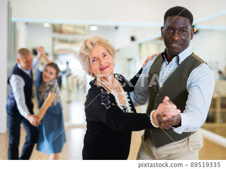 Man and senior woman dancing waltz in studio Man and senior woman dancing waltz in studio 89519335