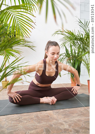 Young woman going yoga exercise at home. Health care online lessons Young woman going yoga exercise at home. Health care online lessons 89519341