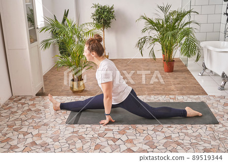Young woman going yoga exercise at home. Health care online lessons Young woman going yoga exercise at home. Health care online lessons 89519344