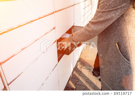 Postal terminal. Post delivery automat service and hands with parcel courier box. Mail delivery and post service concept. 89519717