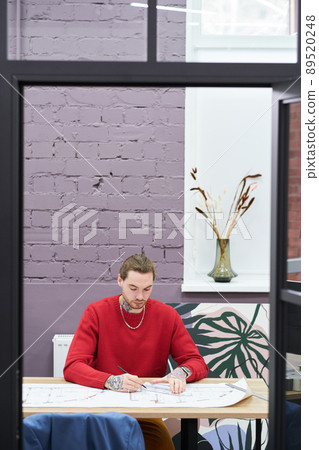 Architect working with blueprints in office Architect working with blueprints in office 89520248