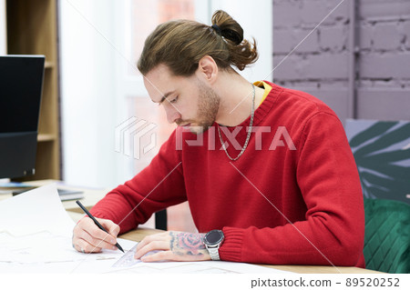 Designer drawing project at table 89520252