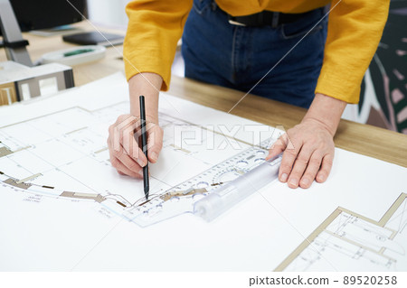 Woman working on construction plan at desk Woman working on construction plan at desk 89520258