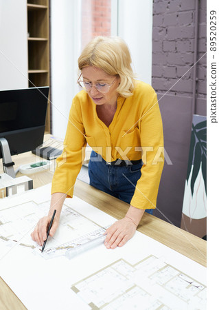 Female engineer working with blueprint Female engineer working with blueprint 89520259