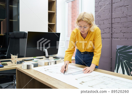 Female architect drawing blueprint at office Female architect drawing blueprint at office 89520260