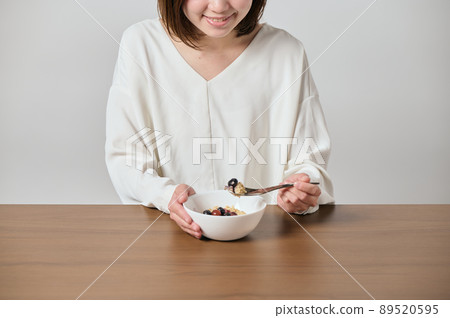 Young vegan woman eating oatmeal 89520595