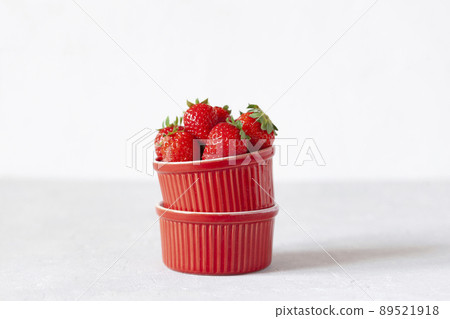 Fresh strawberries in a red bowl closeup 89521918