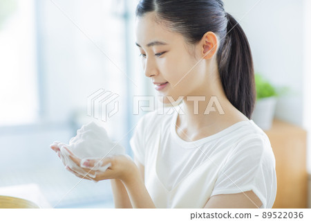 A young woman cleansing face 89522036