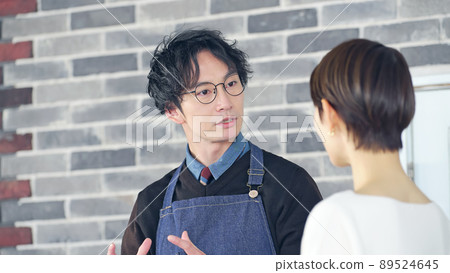A man wearing an apron to serve customers A man wearing an apron to serve customers 89524645