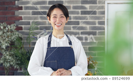 A female clerk wearing an apron to meet you 89524699