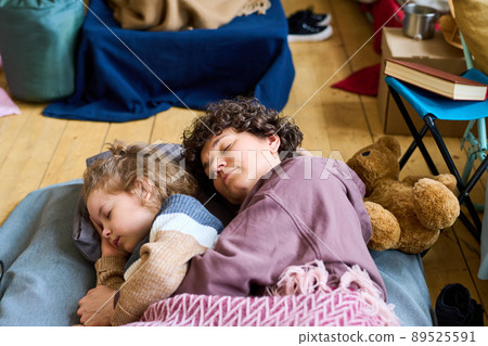Adorable boy with blond curlt hair and his mother sleeping on the floor Adorable boy with blond curlt hair and his mother sleeping on the floor 89525591