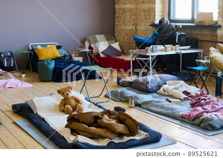 Part of spacious room with sleeping places on wooden floor for refugees Part of spacious room with sleeping places on wooden floor for refugees 89525621
