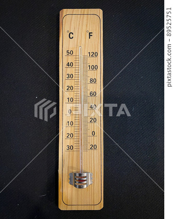 Analogue wooden thermometer with red measuring liquid on black background Analogue wooden thermometer with red measuring liquid on black background 89525751