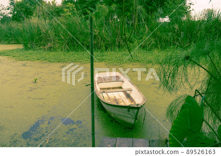 Natural lake landscape with white small fishing boat to the wooden pier Natural lake landscape with white small fishing boat to the wooden pier 89526163