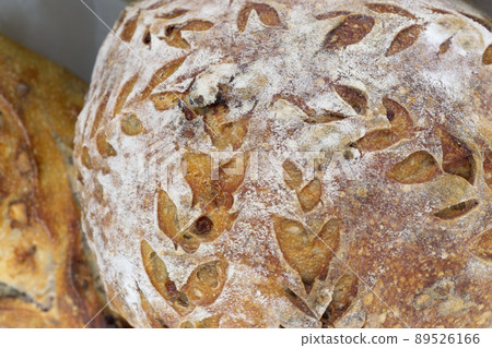 Bread close-up. Freshly baked sourdough bread with a golden crust . Concept bakery , texture sourdough bread Bread close-up. Freshly baked sourdough bread with a golden crust . Concept bakery , texture sourdough bread 89526166